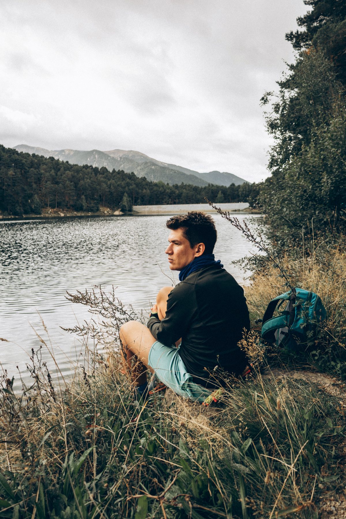 George sitting by a mountain lake in Andorra